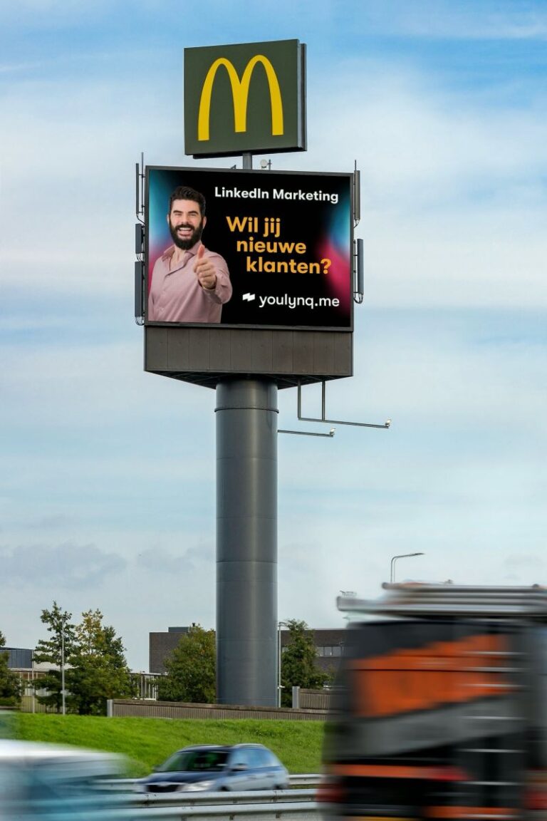 A roadside billboard below a McDonald's sign displays a LinkedIn Marketing advertisement. It features a man giving a thumbs-up and the text "Wil jij nieuwe klanten?", with the website "youlynq.me" at the bottom. A blurred truck is visible passing by.
